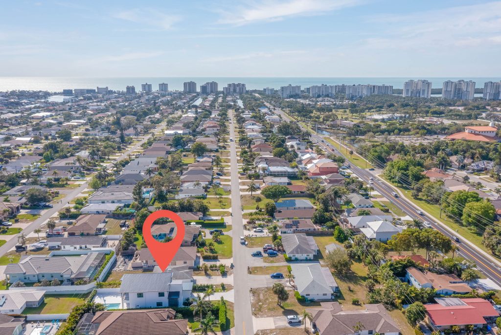 Aerial view of a coastal neighborhood in Florida with a red location marker over a highlighted home.