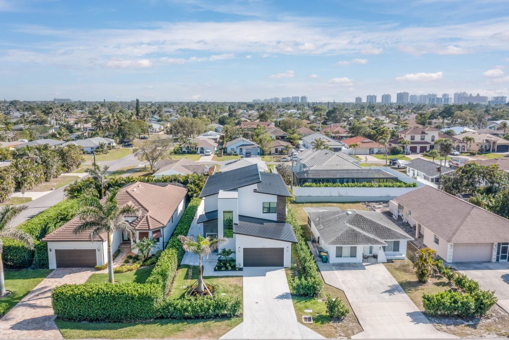 Modern custom home in Naples Park, FL built by Fortress Custom Builders, surrounded by older single-family homes